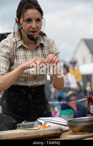 Rachel De Thample dimostrando all'aperto una buca per il fuoco per la cottura e la preparazione di una pasta acida pizza. River Cottage Salone del Cibo. Devon. 2019 Foto Stock