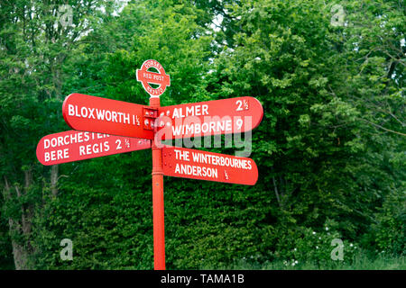 Segnavia rosso (fingerpost), Dorset, Regno Unito Mostra griglia di riferimento all'roundel (883970). tra Bere Regis e Wimborne Minster su un31 Foto Stock
