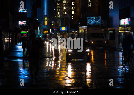 New York City di notte sotto la pioggia con luci che riflettono in strada - Manhattan - New York City Foto Stock