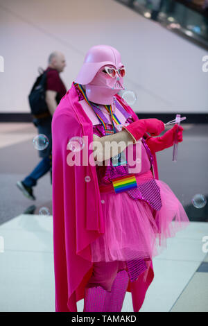Cosplayer con casco rosa di Darth Vader, mantello e tutù che soffia bolle alla Star Wars Celebration 2019, Chicago, Illinois, USA. Foto Stock