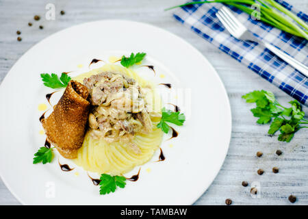 Carni bovine stroganoff con purè di patate, pancake russo e prezzemolo. Cafe menu su un bianco sullo sfondo di legno con copia spazio. Foto Stock