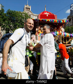 Hare Krishna devoti sono visti tirando un carro decorativo alto otto metri durante il Carnevale Ratha-Yatra di carri a Kiev. Secondo la mitologia, la Ratha Yatra risale a circa 5 mila anni quando dio indù Krishna, insieme con il suo fratello più anziano Balaram e sorella Subhadra, sono stati tirati su un carro da Kurukshetra a Vrindavana da Krishna devoti del. Ratha Yatra a cui si fa riferimento anche come Rathayatra, Rathajatra o carro il festival è famoso corteo pubblico in un carro, celebrato ogni anno in India e attira oltre un milione di pellegrini indù per partecipare alla processione. L'elemento centrale di Foto Stock