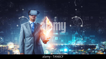 Imprenditore in VR auricolare e touch screen e ethereum simbolo. I supporti misti Foto Stock