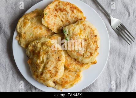 Torte di patate accumulate su piastra bianca con serve la forcella - vista superiore foto Foto Stock