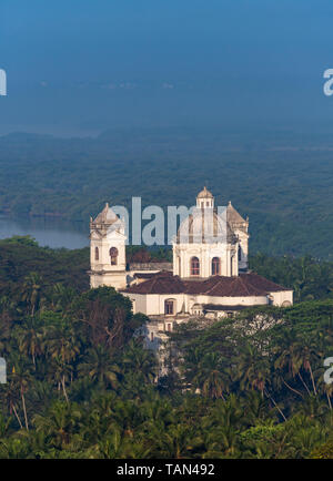 Vista in lontananza San Gaetano Chiesa tra alberi di palma, Old Goa, India Foto Stock