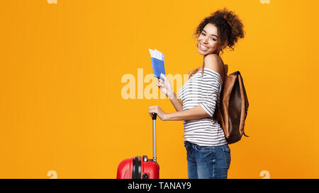 Il concetto di viaggio. Felice Afro turistico con passaporto Foto Stock
