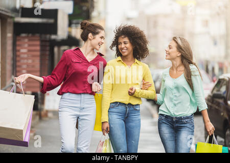 Le ragazze a piedi lungo una strada di città dopo lo shopping Foto Stock