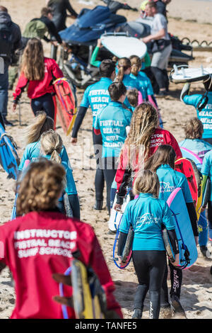 Istruttori di Surf e surf novizi con il Fistral Beach Surf School l'impostazione off per una lezione di surf a Newquay in Cornovaglia. Foto Stock