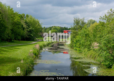 Il treno attraversa ponte sopra il Sankey canal in Sankey Valley Park. Foto Stock