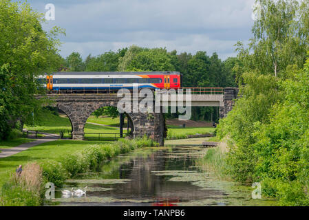 Il treno attraversa ponte sopra il Sankey canal in Sankey Valley Park. Foto Stock