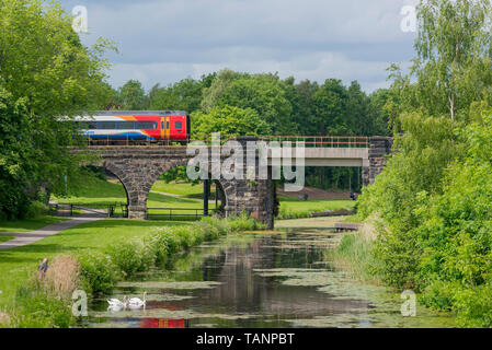 Il treno attraversa ponte sopra il Sankey canal in Sankey Valley Park. Foto Stock