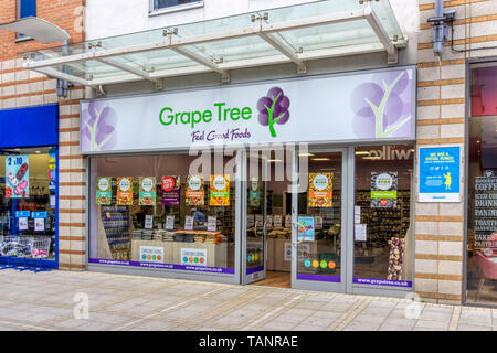 Un ramo di albero di uva la salute dei negozi di alimentari in Broad Street, King's Lynn. Foto Stock