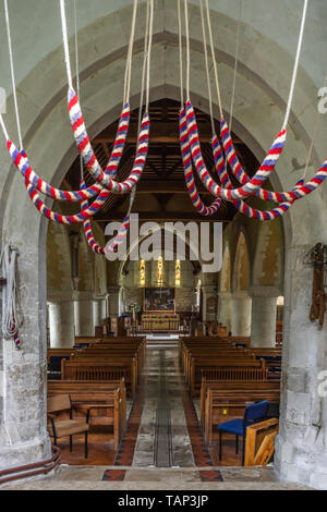 Campanile della chiesa corde appendere dalla torre all'interno della chiesa di Santa Maria con vista della navata verso l altare, Selborne, Hampshire Foto Stock