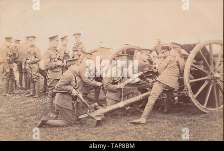 Vintage Cartolina fotografica che mostra esercito britannico di soldati. Royal Artillery Gusci di caricamento nel loro pistole. Foto Stock