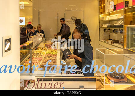 Persone che acquistano macarons in Pierre Marcolini un belga di lusso negozio di cioccolato Les Galeries Royales Saint-Hubert , vetrato shopping arcade a Bruxelles . Foto Stock