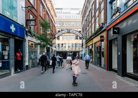London, Regno Unito - 15 Maggio 2019: Donna va shopping a Carnaby Street con lusso fashion retail negozi nella zona di Soho nella City of Westminster, Londra Foto Stock