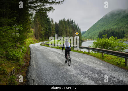 Ciclista femmina sul percorso 57 vicino al Sognefjord, Norvegia Foto Stock