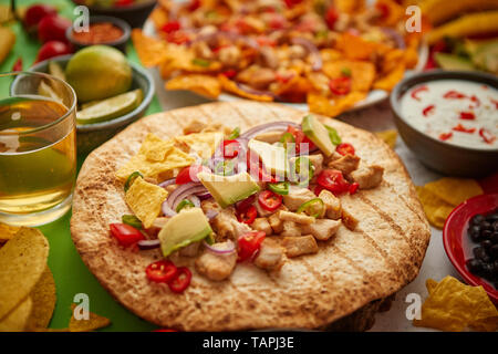 Una foto aerea di un assortimento di molti diversi piatti messicani, compresi i tacos, guacamole, nachos con pollo alla griglia, tortillas, salse e oth Foto Stock