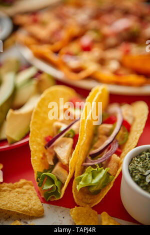 Close up su croccante di tacos con vari freschi piatti messicani assortimento nel retro. Posto sulla tavola colorati. Con nachos, Tacos, tortillas, grill Foto Stock