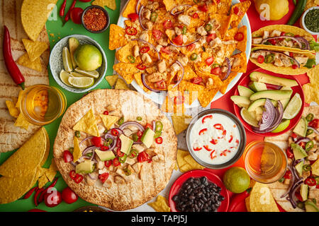 Una foto aerea di un assortimento di molti diversi piatti messicani, compresi i tacos, guacamole, nachos con pollo alla griglia, tortillas, salse e oth Foto Stock