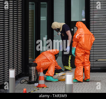 Duesseldorf, Germania. 27 Maggio, 2019. I vigili del fuoco del Düsseldorf vigili del fuoco si stanno preparando per entrare in un edificio di uffici presso l'aeroporto di Düsseldorf in tute di protezione. A causa di uno sconosciuto polvere bianca in costruzione, il dipartimento dei vigili del fuoco è andato su una operazione su larga scala. Credito: Johannes Neudecker/dpa/Alamy Live News Foto Stock