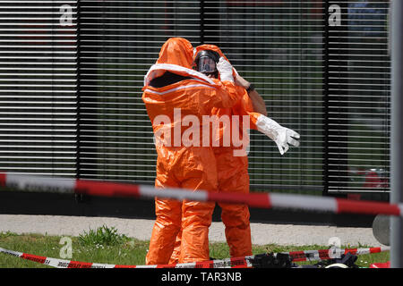 Duesseldorf, Germania. 27 Maggio, 2019. I vigili del fuoco del Düsseldorf vigili del fuoco vestito in abiti di protezione nella parte anteriore di un edificio di uffici presso l'aeroporto di Düsseldorf. A causa di uno sconosciuto polvere bianca in costruzione, il dipartimento dei vigili del fuoco è andato su una operazione su larga scala. Credito: Johannes Neudecker/dpa/Alamy Live News Foto Stock