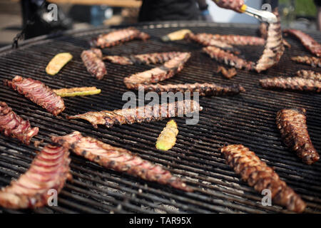Grigliata di costolette di maiale in cottura sulla griglia. Street food festival. Foto Stock