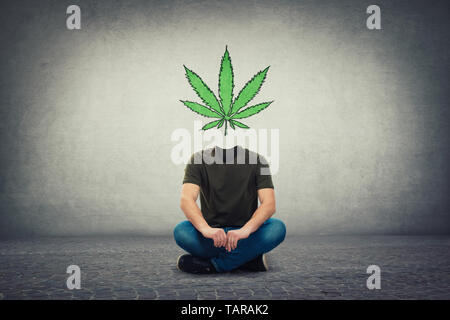 Surreale decapitati guy, volto invisibile seduto sul pavimento con la marijuana leaf invece il simbolo della testa, come cervello cura. La cannabis legalizzazione come medico d Foto Stock