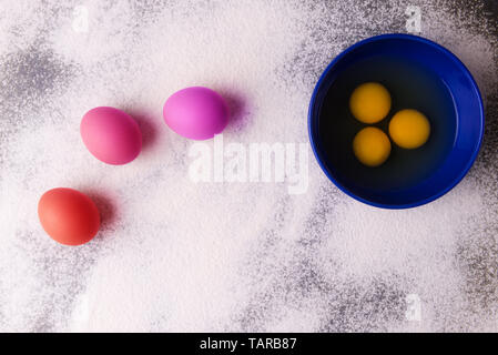 Preparazione per la cottura di Pasqua, colorata e la fila di uova sulla farina oggetto sullo sfondo di pietra Foto Stock