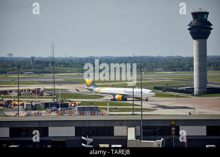 Aeroporto di Manchester torre di controllo, di rullaggio t il piedistallo è un Thomas Cook aeroplano Foto Stock