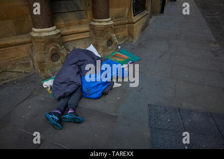 In contrasto senzatetto sonno agitato Manchester city center King Street, esclusiva destinazione per lo shopping Foto Stock