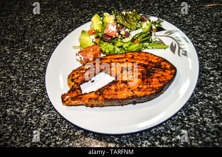 Salmone alla griglia ricco di omega 3 e a foglia verde insalata di verdure a pranzo su una piastra Foto Stock