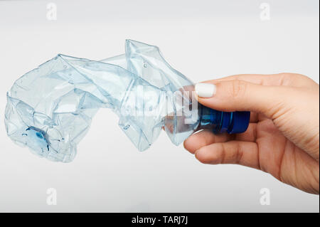 Mano che tiene il cestino la bottiglia di plastica isolato su bianco di sfondo per studio Foto Stock