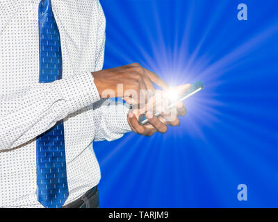 Giovani indiani business man facendo clic premendo il pulsante sul telefono cellulare con il raggio di luce blu su sfondo colorato. Per contattare il servizio di assistenza clienti di tecnologia arti Foto Stock