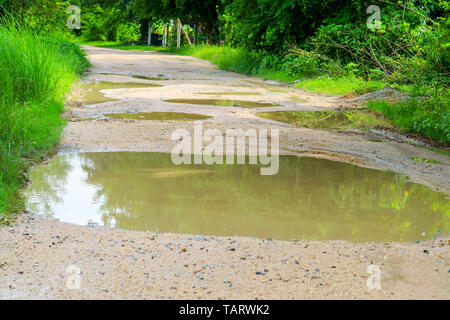 Rural Dirt strade sono inondate durante la stagione delle piogge, i disagi del viaggio sconnesso Foto Stock