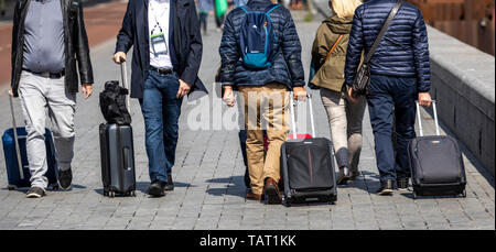 Turisti e visitatori con carrelli, in modo da e per la stazione ferroviaria di Amsterdam Centraal, Paesi Bassi, Foto Stock