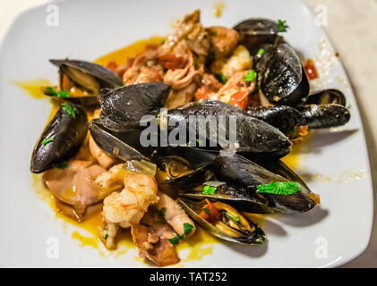 Piatto tipico della cucina italiana, zuppa di pesce "a sessanta ' senza spine: cozze, gamberi, Smooth-Hound, rana pescatrice in salsa di pomodoro con cipolle di Tropea, w Foto Stock