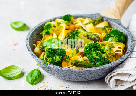 Pasta Vegetariana con broccoli, asparagi e i ceci in una padella. Cibo Vegan concetto. Foto Stock