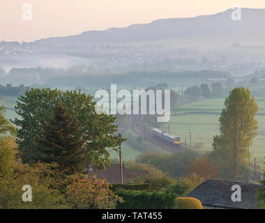 Arriva Nord classe rampa 321 treno elettrico subito dopo aver lasciato skipton nella valle dell Aire in una nebbiosa mattina con un treno per Leeds Foto Stock