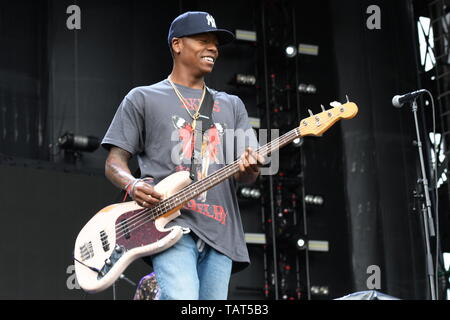 Bassista chitarrista Franz Lione è mostrato esibirsi sul palco durante un 'live' stand up aspetto con il tornello. Foto Stock