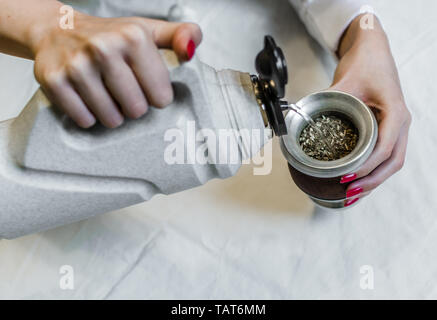 Giovane donna preparazione tradizionale di yerba mate tè Foto Stock