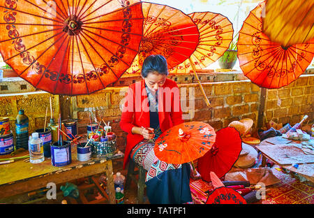 PINDAYA, MYANMAR - 19 febbraio 2018: il pittore di Shan workshop carta decora red fatti a mano ombrello birmano con tradizionale motivo floreale, SU F Foto Stock