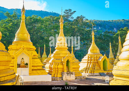 La Shiny pagode dorate di Nottieni Pyaw Taw Paya ornato di decorazioni scolpite e statue di Buddha in piccole nicchie, Pindaya, Myanmar. Foto Stock
