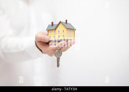 Piccola casa gialla miniaturizzato con chiavi in mano Foto Stock