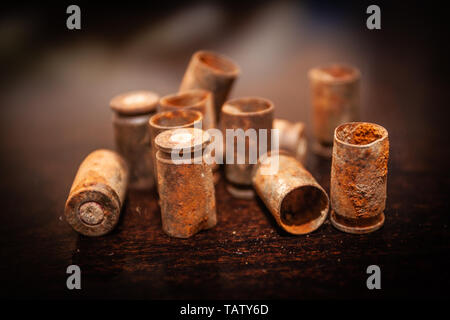 Una pila bullet gusci su uno sfondo di legno Foto Stock