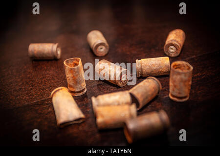 Una pila bullet gusci su uno sfondo di legno Foto Stock
