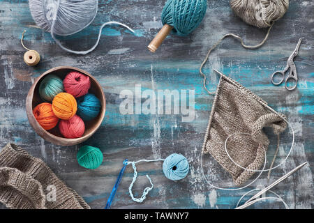 Verde scuro dei filati di lana e aghi di tessitura e maglieria creativa hobby lo sfondo in blu turchese colori Foto Stock