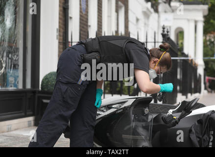 Controllo di polizia un ciclomotore al di fuori delle ore di casa sulla Duke Street, Westminster, dove ciclomotore-riding rapinatori di mira la luxury watch shop, rendendo con gli oggetti rubati dal fracassato vetrina. Foto Stock