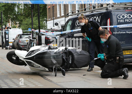 Controllo di polizia un ciclomotore al di fuori delle ore di casa sulla Duke Street, Westminster, dove ciclomotore-riding rapinatori di mira la luxury watch shop, rendendo con gli oggetti rubati dal fracassato vetrina. Foto Stock