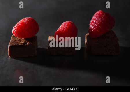 Brownie al cioccolato con topping di lampone. Bassa illuminazione tasto Foto Stock